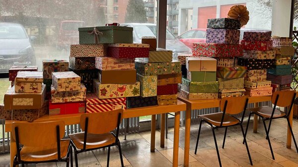 Zahlreiche Geschenke liegen gestapelt auf einem Tisch