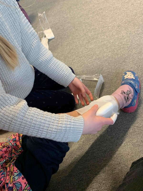 An einem Kinderbein wird ein Verband angelegt.